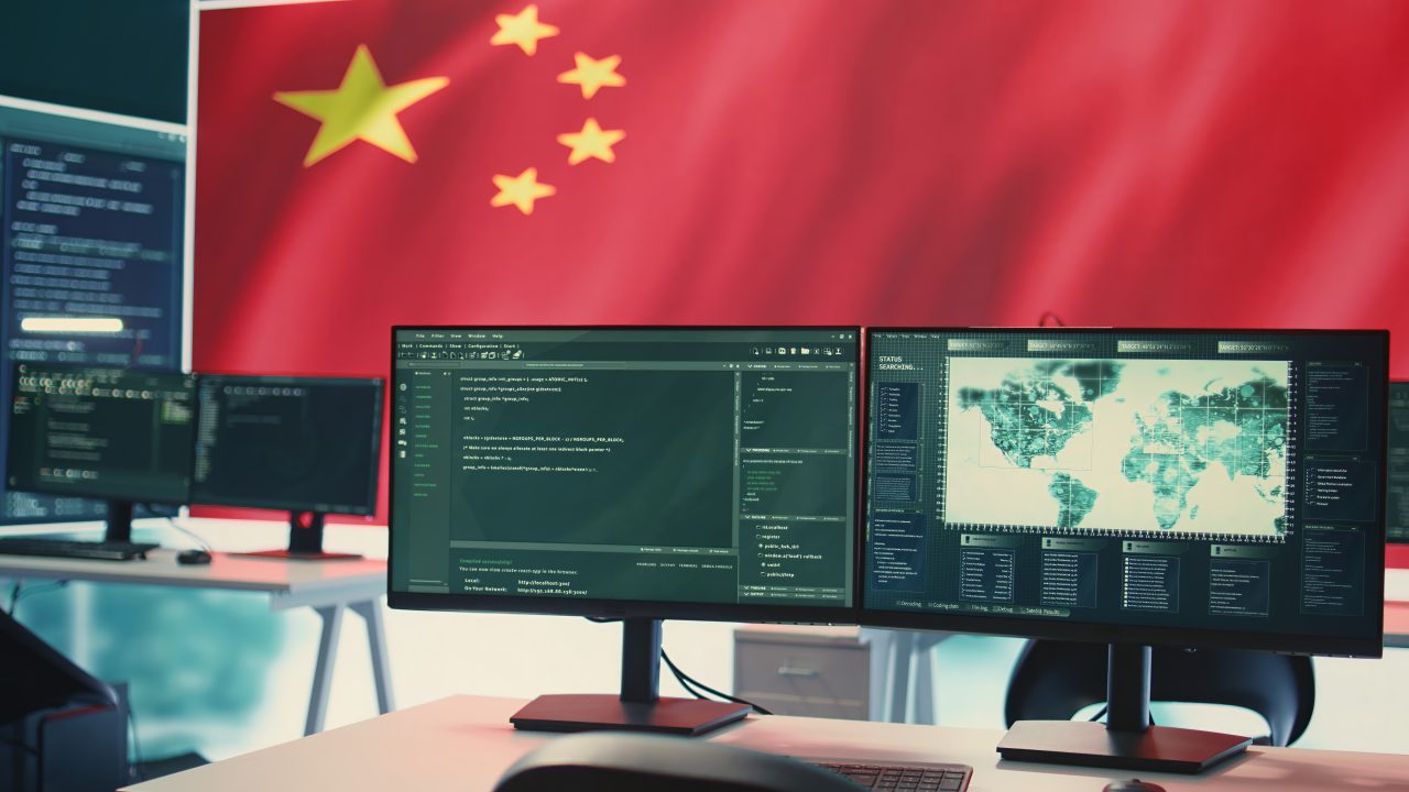 Governmental cyber operations room with Chinese flag on big screen